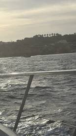 An unclear image of a boat in the distance, with a blurred view of the water and shoreline.