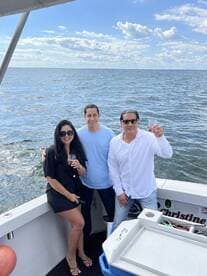 A cheerful group enjoys drinks on a boat, capturing a memorable moment on the water — perfect for celebrations and gatherings.