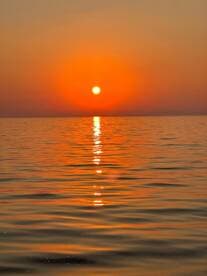 A serene sunset over calm waters, creating a picturesque reflection — perfect for capturing the beauty of nature.