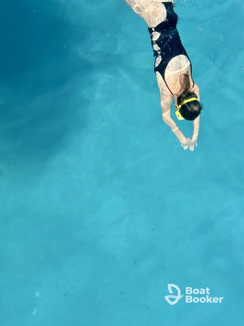 A swimmer dives into crystal-clear waters, showcasing the thrill of snorkeling adventures — perfect for exploring vibrant marine life.