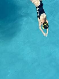 A swimmer dives into crystal-clear waters, showcasing the thrill of snorkeling adventures — perfect for exploring vibrant marine life.
