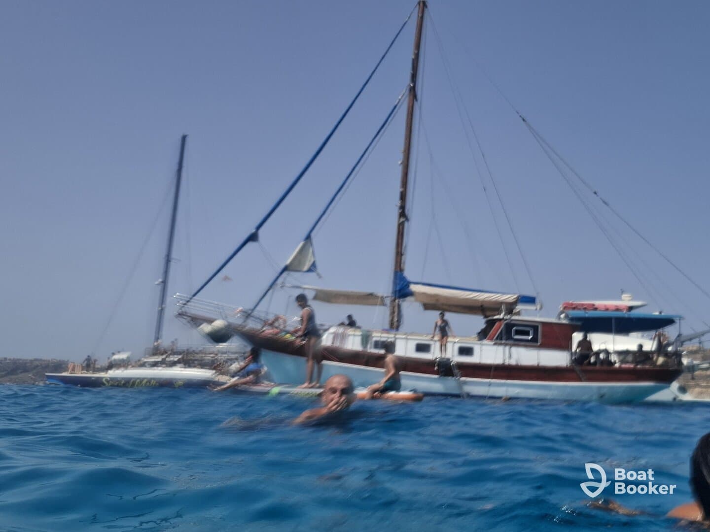 A lively scene captures a group enjoying the water near a boat, showcasing the fun and excitement of on-water activities.