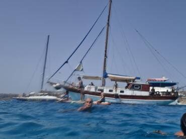 A lively scene captures a group enjoying the water near a boat, showcasing the fun and excitement of on-water activities.