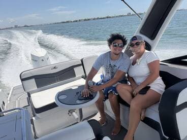 A couple enjoys a sunny day on a boat, capturing the essence of fun and relaxation on the water.