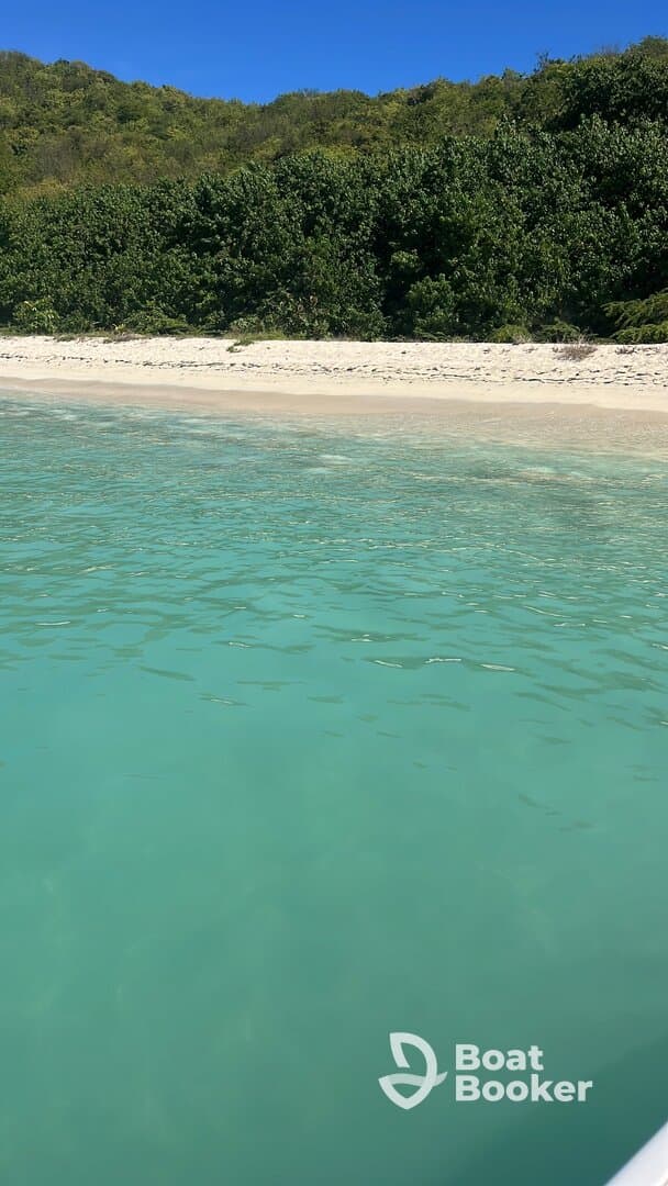 A serene view of a pristine beach with turquoise waters and lush greenery, perfect for showcasing tropical destinations and relaxing getaways.