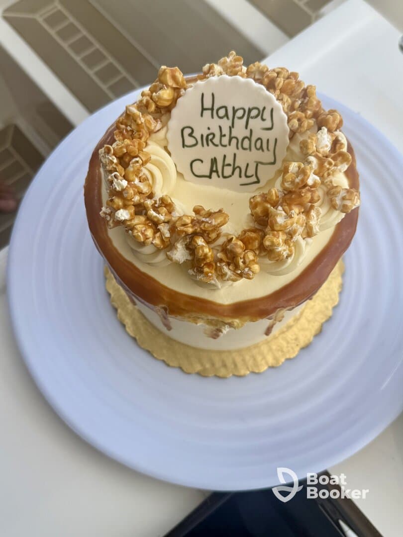 A beautifully decorated birthday cake with popcorn topping, perfect for celebrating special occasions on board.