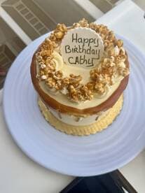 A beautifully decorated birthday cake with popcorn topping, perfect for celebrating special occasions on board.
