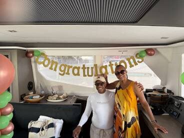 A joyful celebration aboard a boat, featuring a 'Congratulations' banner and two guests enjoying the festive atmosphere — perfect for special occasions on the water.