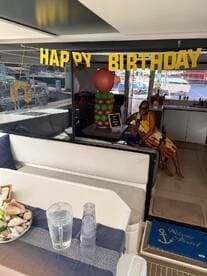 A festive birthday celebration inside a boat cabin, featuring decorations and a guest enjoying the ambiance. Perfect for intimate gatherings on the water.