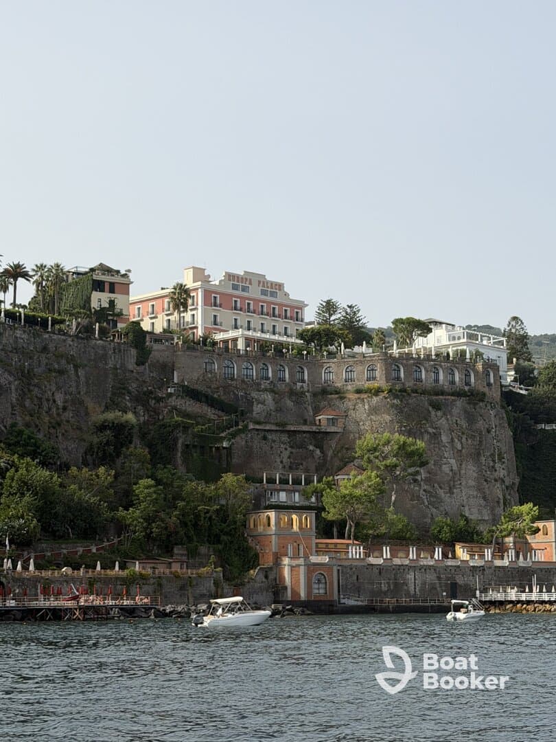 A picturesque view of the coastline featuring the Europa Palace hotel, with boats gently bobbing in the water — a perfect representation of coastal charm and relaxation.