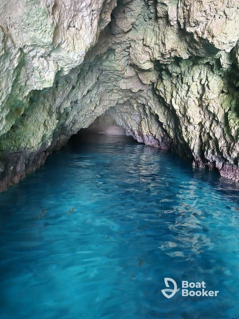 A stunning view of a cave with crystal-clear blue water, showcasing the natural beauty of the destination — perfect for eco tours and exploration.