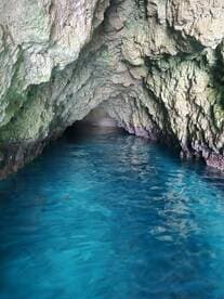 A stunning view of a cave with crystal-clear blue water, showcasing the natural beauty of the destination — perfect for eco tours and exploration.