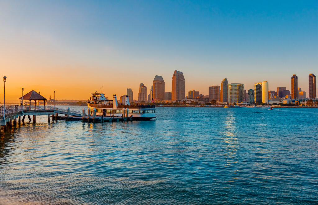 A view of a ferry from Coronado Island overlooking San Diego at sunset